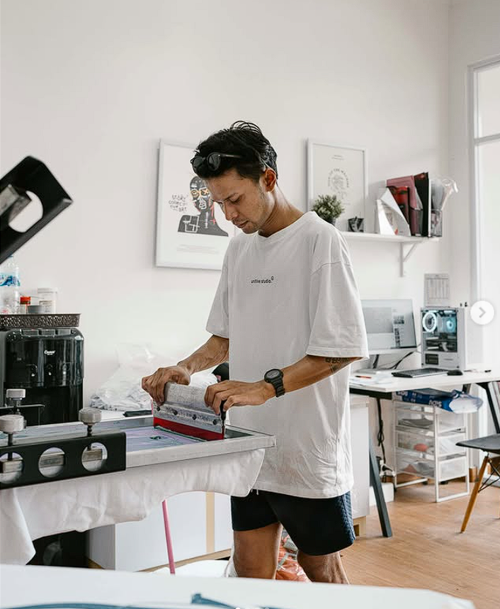 Proses sablon manual kaos di unitive studio dengan alat screen printing.